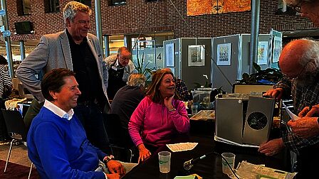 Repair Cafe Raadhuis Rhenen, vrijwilliger repareert een apparaat in bijzijn van de eigenaren..