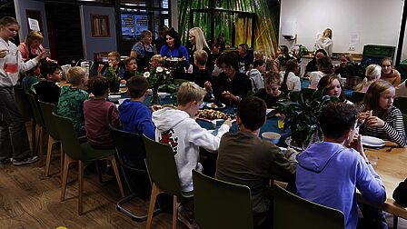 Overzichtsfoto van alle tafels met de gasten tijdens de lunch. 