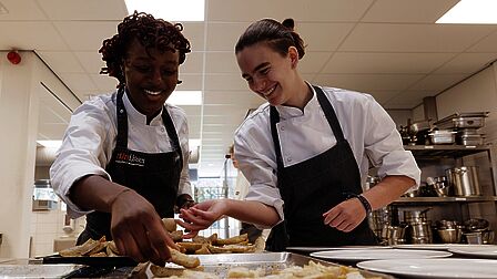 Twee studenten bereiden de verse frieten. 