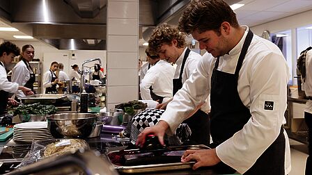 Studenten zijn aan de slag met gered voedsel. Een student is bieten aan het raspen. 