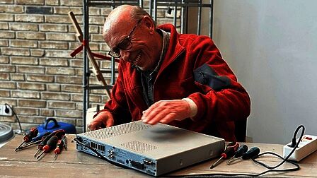 Repair café in Scherpenzeel. Een vrijwilliger maakt een kapot apparaat. 