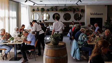 Overzichtsfoto van de mensen die aan het lunchen zijn in het restaurant van Vakschool Wageningen.