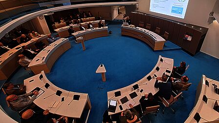 de informatiebijeenkomst voor de raadsleden wordt gehouden in de raadszaal Ede. De raadsleden luisteren aandachtig naar de presentatie. 