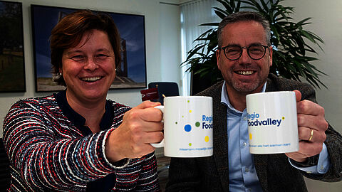 Carolien Huisman en Arnold Versteeg geven de koffiemok door aan het volgende onderwerp. 